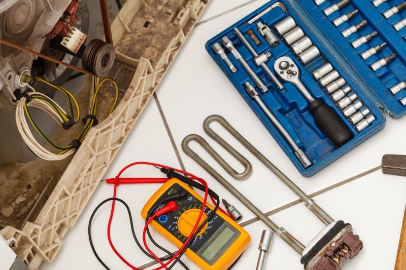Engineer repairing a washing machine in Hampton Hill